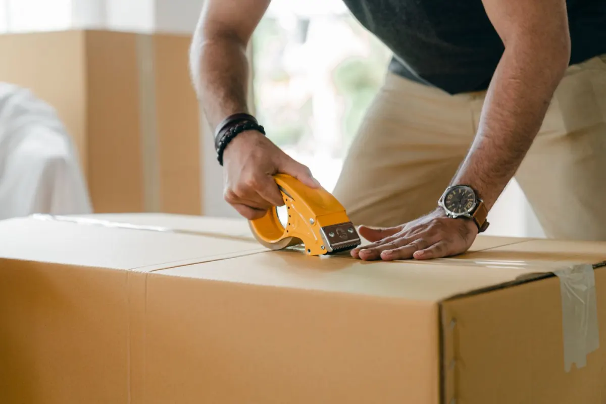 Dán băng keo kín nắp thùng hàng trước khi gửi